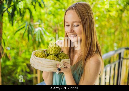 Cherimoya in einer wiederverwendbaren Tasche in weiblichen Händen. Null-Abfall-Konzept, plastikfreies Konzept. Gesunde, saubere Ernährung und Entgiftung. Sommerfrüchte Stockfoto