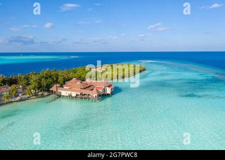 Luftaufnahme der maledivischen Insel mit Holzhäusern auf einem flachen Wasser eines Riffs im Indischen Ozean Stockfoto