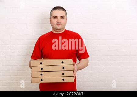 Foto eines glücklichen Mannes vom Lieferservice, der Essen bestellt. Stockfoto