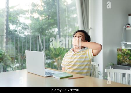 Gelangweilter Junge zu Hause Schulbildung, Stockfoto