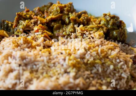 Nahaufnahme der jamaikanischen Curried Goat serviert mit Reis und Erbsen Stockfoto