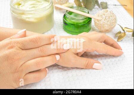 Handhautpflege. Nahaufnahme von schönen reifen erwachsenen weiblichen Händen mit natürlichen Maniküre Nägel. Nahaufnahme der Hand einer Frau, die ihren weichen, silky gesunden S berührt Stockfoto