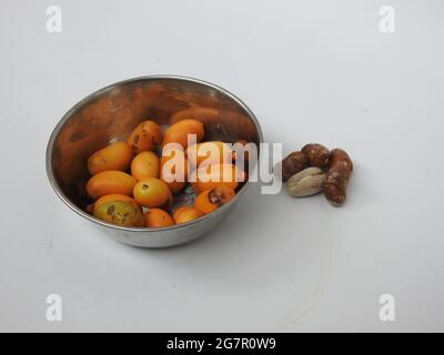 Teller mit rohen Zeidi-Datteln und Samen isoliert auf weißem Hintergrund Stockfoto