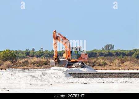 Huelva, Spanien - 1. Oktober 2020: Bagger arbeitet in der Salzproduktion im Naturschutzgebiet Marismas del Odiel. Die traditionelle Meersalzproduktion ist Salz th Stockfoto