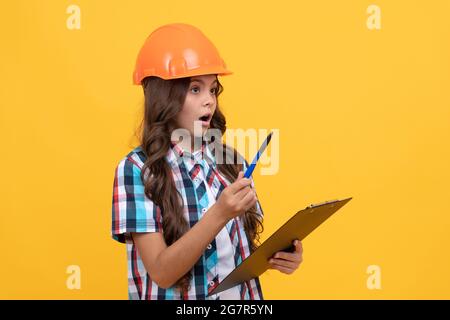 Sicherheit Arbeit Expertise. Stauned Mädchen in schützenden Hut machen Notizen. Stockfoto