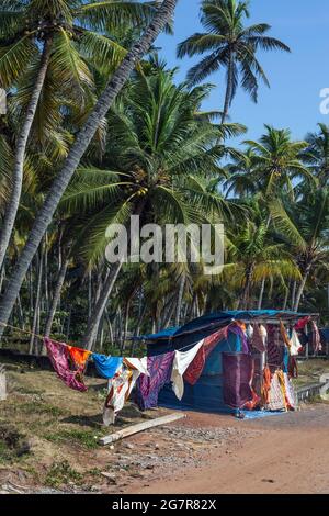 Straßenrand Stand verkauft Stoffe, Kunsthandwerk, Textilien, Bettwäsche mit idyllischen Palmen, Varkala Beach, Kerala, Indien Stockfoto