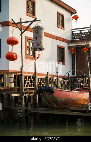 Ein modernes „Pang uk“- oder Stelzenhaus mit traditionellem chinesischen Ruderboot und roten Laternen in Tai O, Lantau Island, Hongkong Stockfoto