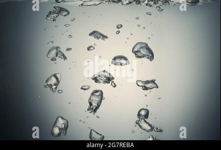 Luftblasen steigen durch klares Wasser Stockfoto