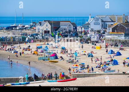 Lyme Regis, Dorset, Großbritannien. Juli 2021. Wetter in Großbritannien: Familien und Sonnenanbeter kommen früh an, um sich einen Platz am Sandstrand zu sichern, um den heißen Sonnenschein im Badeort Lyme Regis zu genießen, während die Sommerferien der Schule beginnen. Kredit: Celia McMahon/Alamy Live Nachrichten Stockfoto