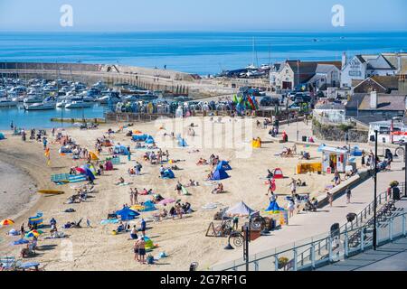 Lyme Regis, Dorset, Großbritannien. Juli 2021. Wetter in Großbritannien: Familien und Sonnenanbeter kommen früh an, um sich einen Platz am Sandstrand zu sichern, um den heißen Sonnenschein im Badeort Lyme Regis zu genießen, während die Sommerferien der Schule beginnen. Kredit: Celia McMahon/Alamy Live Nachrichten Stockfoto