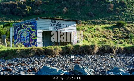 Surfers wechselnder Schuppen mit Medusa-Gemälde an einer Wand in Colac Bay, Southland, Südinsel, Neuseeland. Stockfoto