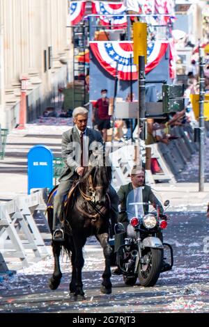 Glasgow, Schottland, Großbritannien. 15. Juli 2021. IM BILD: Harrisons Ford und Boyd Holbrook Stunt-Doubles. Tag 2 der Dreharbeiten von Hollywood-Blockbuster-Film von Indiana Jones 5. Heutige Szenen sagen, dass eine Ticker-Tape-Parade mit marschierenden Bands, winkenden Massen, Presse und den zurückkehrenden Astronauten in einer amerikanischen New Yorker Szene von 1959 stattfindet. Die Straßen sind mit Sternen und Streifen geschmückt, Flaggen und Ammer, und das Harrison Ford Double wurde auf dem Pferd durch die Straßen von Glasgow reiten gesehen. Quelle: Colin Fisher Stockfoto