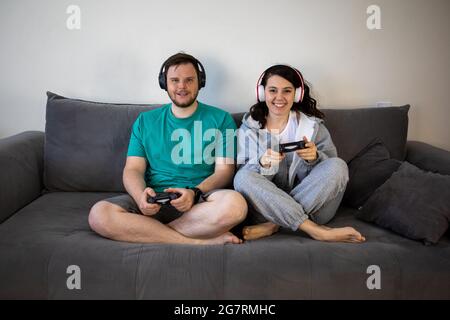 Paar spielen Videospiele zusammen sitzen auf dem Sofa Couch Stockfoto