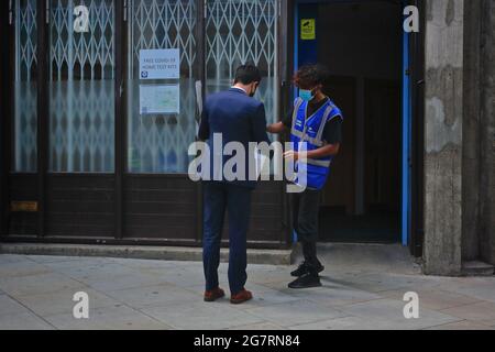 Londom (Großbritannien), 14. Juli 2021: Ein NHS-Mitarbeiter gibt covid Selbsttest-Kits an Mitglieder der Öffentlichkeit auf den Straßen von Zentral-London Stockfoto