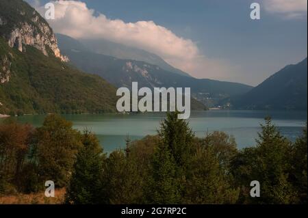 Hinweise und Farbtöne des Herbstes im September in den dichten Wäldern und der Vegetation am Wasser rund um den ‘schönsten See Italiens’, den Lago di Molveno in Trentino-Südtirol. Der See, umgeben von den Gipfeln und Klippen der Brenta-Dolomiten, wurde 1890 vom italienischen Dichter und Schriftsteller Antonio Fogazzaro als „die kostbare Perle in einer noch kostbareren Schatulle“ beschrieben. Das bis zu 124 m (406 ft) tiefe, ruhige Wasser verbirgt einen versteinerten Wald, der vor etwa 3,000 Jahren, während der frühen Eisenzeit, eingetaucht war. Stockfoto