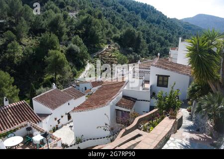 Frigiliana, Spanien. Geflieste Dächer im kleinen Weiler El Acebuchal. Blick aus einem hohen Winkel mit Blick auf die mit Kiefern verkleideten Berge. Landschaftsbild. Stockfoto