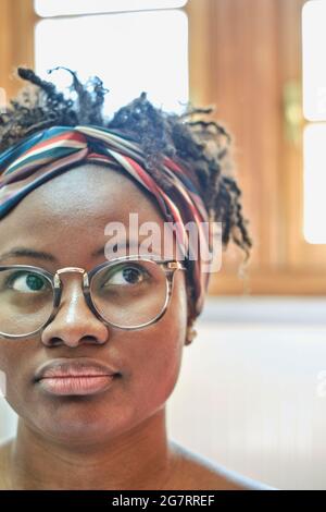 Nahaufnahme Porträt einer jungen schwarzen Frau in einer Brille und Afro-Frisur innen in einem Raum. Lifestyle-Konzept. Stockfoto