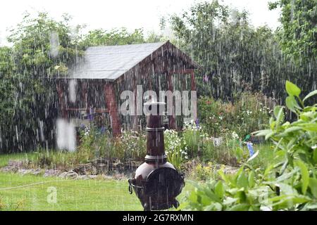 Sintflutartiger Regen an einem Sommertag in einem englischen Landgarten Stockfoto