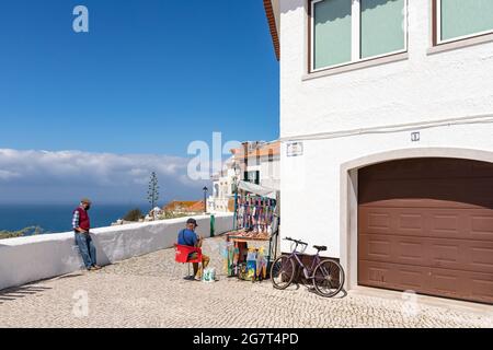 Nazare, Portugal - 28. Juni 2021: Ein Mann stellt in Sitio De Nazare Produkte für seinen Souvenirstand her Stockfoto