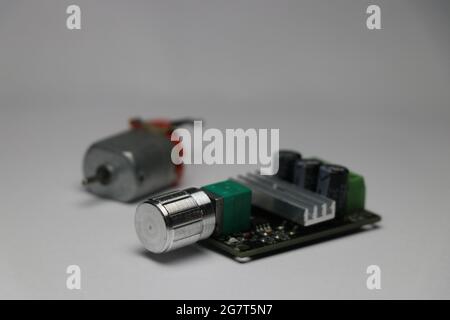 DC-Motor pwm-Drehzahlregler mit dc-Motor im Hintergrund Stockfoto