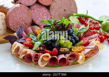 Fleischplatte auf weißem Holzhintergrund. Set Salami. Aufschnitt von verschiedenen Fleischsorten. Antipasto-Set Platte. Fleisch-Snack-Platte. Horizontale Ansicht Stockfoto