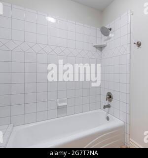 Quadratischer Rahmen Innenraum eines Badezimmers mit Toilettenschüssel und Badewannen-Duschkombination mit Fliesen Stockfoto