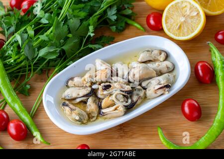 Marinierte Muscheln auf Holzgrund. Fischgerichte Stockfoto