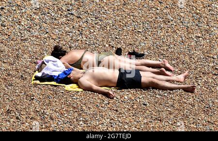 Brighton UK 16. Juli 2021 - Brighton Beach ist an einem heißen, sonnigen Tag voll mit Sonnenanbetern, da das warme Wetter in den nächsten Tagen in Großbritannien voraussichtlich anhalten wird, wobei die Temperaturen am Wochenende die hohen 20 Grad erreichen werden: Credit Simon Dack / Alamy Live News Stockfoto