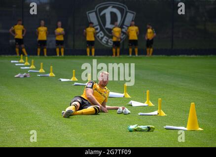 Dresden, Deutschland. Juli 2021. Fußball: 2. Liga, Team-Fotosession, SG Dynamo Dresden, Saison 2021/2021, in der Aok Plus Walter-Fritzsch-Akademie. Dynamos Sebastian Mai liegt während der Fotosession auf dem Spielfeld, während seine Teamkollegen im Hintergrund warten. Quelle: Robert Michael/dpa-Zentralbild/dpa/Alamy Live News Stockfoto