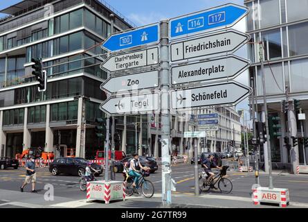 Berlin, Deutschland. Juli 2021. Auf der Leipziger Straße im Bezirk Mitte weisen Schilder den Weg für die Verkehrsteilnehmer, auch zu längst geschlossenen Orten wie dem Flughafen Tegel hier. Die Schilderanordnung, nahe der ehemaligen Grenze zwischen West- und Ost-Berlin, spiegelt auch die gespaltene Stadt vor dem Mauerfall wider. Die linken Schilder weisen auf den westlichen Teil der Stadt, die rechten auf den östlichen Teil. Quelle: Wolfgang Kumm/dpa/Alamy Live News Stockfoto