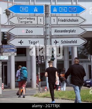 Berlin, Deutschland. Juli 2021. Auf der Leipziger Straße im Bezirk Mitte weisen Schilder den Weg für die Verkehrsteilnehmer, auch zu längst geschlossenen Orten wie dem Flughafen Tegel hier. Die Schilderanordnung, nahe der ehemaligen Grenze zwischen West- und Ost-Berlin, spiegelt auch die gespaltene Stadt vor dem Mauerfall wider. Die linken Schilder gehören zum westlichen Teil der Stadt, die rechten zum östlichen Teil. Quelle: Wolfgang Kumm/dpa/Alamy Live News Stockfoto