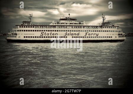 Die Staten Island Ferry, die ihren Hafen in Lower Manhattan, New York City verlässt. Starker Profilwinkel des Schiffes im East River. Stockfoto