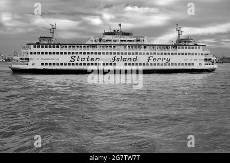 Die Staten Island Ferry, die ihren Hafen in Lower Manhattan, New York City verlässt. Starker Profilwinkel des Schiffes im East River. Stockfoto