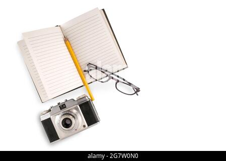 Retro-Kamera mit liniertem Notizbuch und gelbem Bleistift und Brille isoliert auf weißem, Reisekonzept, Kopierraum Stockfoto