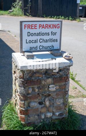 Eine Spendenbox für den Parkplatz für die örtliche Kirche und Wohltätigkeitsorganisationen aus Steinen am Strand von Suffolk Stockfoto