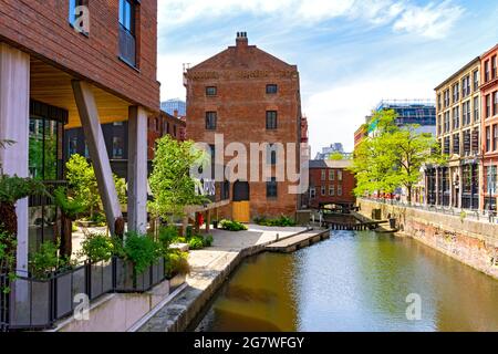 Der Rochdale-Kanal mit der Kampus-Entwicklung auf der linken Seite und Canal Street auf der rechten Seite. Manchester, England, Großbritannien Stockfoto