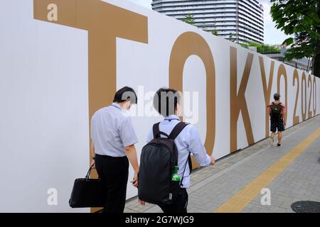 Tokio, Japan. Juli 2021. Die Menschen gehen an einem großen Tokyo 2020 Schild um das Nationale Olympiastadion Gaiemmae vorbei. Das Organisationskomitee der Olympischen Spiele in Tokio plant, die verspäteten Spiele am 21. Juli zu eröffnen, trotz der Unsicherheit darüber, welche Maßnahmen zu ergreifen sind, um die Sicherheit von Athleten, Zuschauern und der lokalen Bevölkerung im Hinblick auf die anhaltende COVID-19-Pandemie zu gewährleisten. Kredit: SOPA Images Limited/Alamy Live Nachrichten Stockfoto