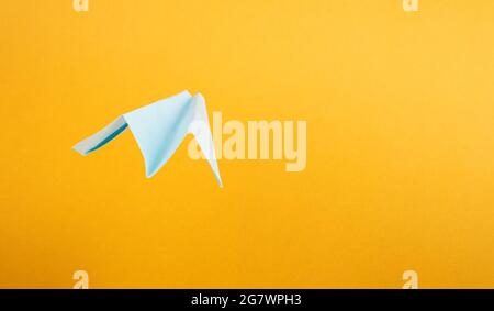 Sommertourismus, Origami-Papierflugzeug auf gelbem Hintergrund mit Kopierraum. Stockfoto