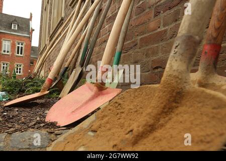 Erftstadt, Deutschland. Juli 2021. Schaufeln stehen an einer Wand, mit der Helfer Sandsäcke gefüllt haben. Sie werden benötigt, um Staudämme zu sichern, die durch die Überschwemmungen aufgeweicht wurden. Kredit: David Young/dpa/Alamy Live Nachrichten Stockfoto