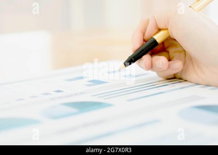 Eine Geschäftsfrau hält einen Stift und analysiert Daten Stockfoto