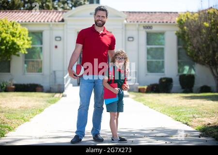 Vater unterstützt und motiviert Sohn. Kindererziehung. Kind geht zur Grundschule. Stockfoto