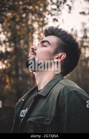Porträt eines jungen russischen Mannes mit Bart und stilvoller Frisur im Wald Stockfoto