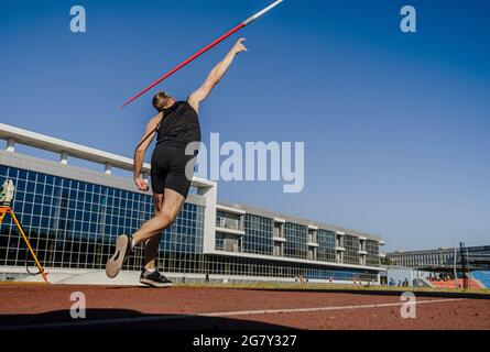 Rücken männlichen Athleten Speer werfen bei Leichtathletik-Wettbewerb Stockfoto