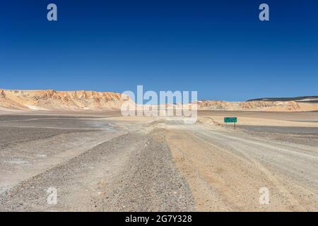 Straßenschild auf grünem Hintergrund in der Atacama-Wüste nach Copiapo und Ojos del Salado, dem höchsten Vulkan der Erde Stockfoto