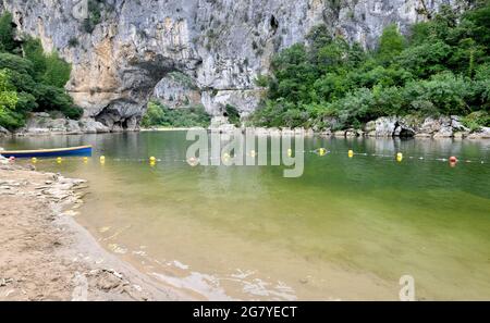 Boot und schwimmt auf einem Fluss die Schluchten der Ardèche in Frankreich und Bogen in Klippe Hintergrund Stockfoto