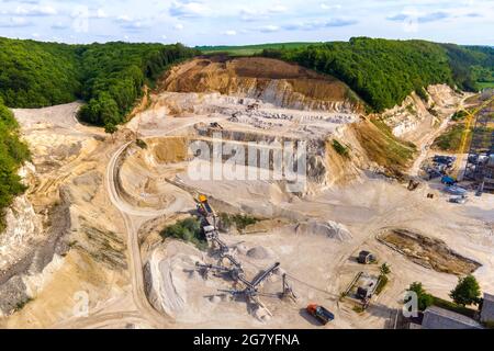 Tagebau von Bausandsteinmaterialien mit Baggern und Muldenkipper am Förderband. Stockfoto