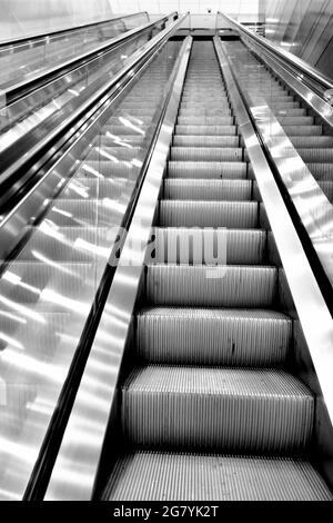 Rolltreppe im Bürogebäude leer von allen Menschen, starke Perspektivlinien, Blick nach oben. Stockfoto