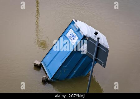 Hattingen, NRW, Deutschland. Juli 2021. Eine tragbare Toilette „Dixi“ ist eingestürzt und ist von Hochwasser umgeben. Die Ruhr hat ihre Böschung, Felder und viele Gärten, Keller und Grundstücke in der Nähe der Stadt Hattingen im Ruhrgebiet in Nordrhein-Westfalen überflutet. NRW ist nach starken Regenfällen in den letzten Tagen von schrecklichen Überschwemmungen heimgesucht worden. Bei den Überschwemmungen in Deutschland sind bisher mehr als 80 Menschen ums Leben gekommen. Kredit: Imageplotter/Alamy Live Nachrichten Stockfoto