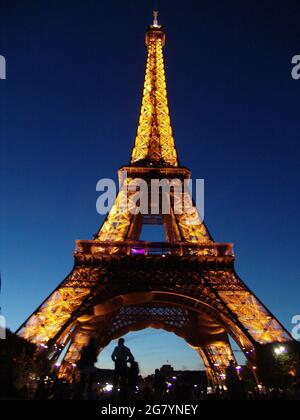 PARIS, FRANKREICH - 24. Aug 2010: Eine vertikale Aufnahme des Eiffelturms in der Nacht vor einem klaren blauen Himmel Stockfoto