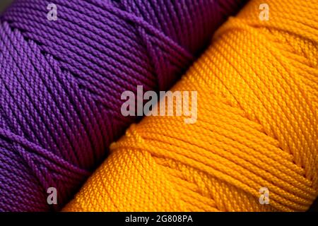 Nahaufnahme von verschiedenen bunten Fadenrollen auf einer bunt gestreiften Matte Stockfoto